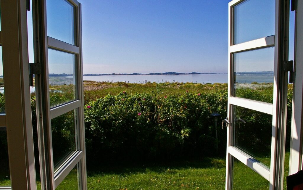 open window looking onto countryside with hinges visible